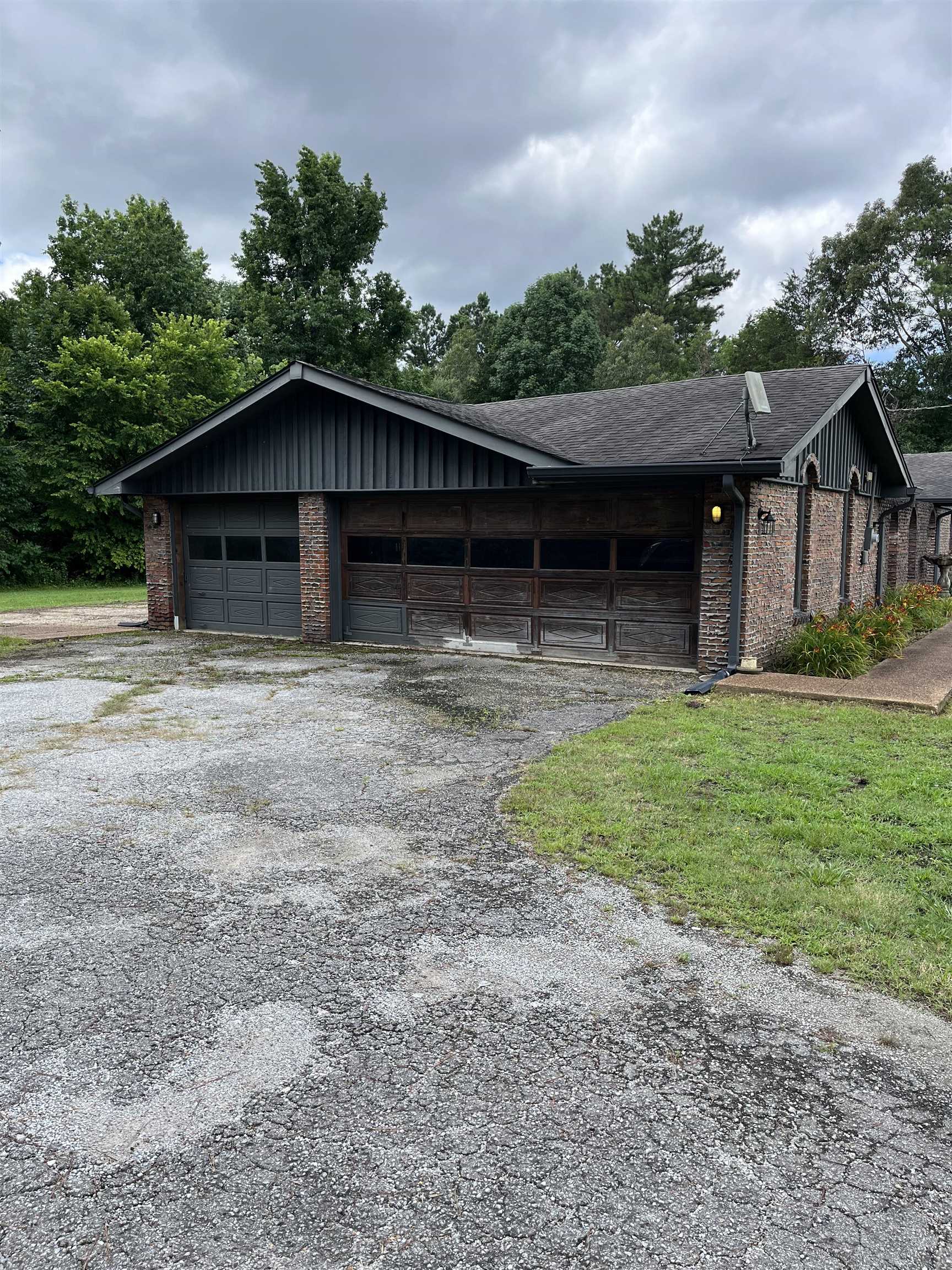 1125 Tyson Road Toone, TN 38381 - Photo 2 of 12 Brick exterior featuring a multi-car garage with two distinct door styles