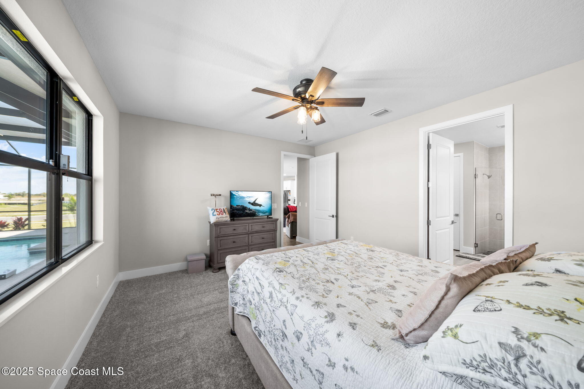 2846 Silverlefe Lane Melbourne, FL 32940 - Photo 19 of 58 a bedroom with a bed desk and a window