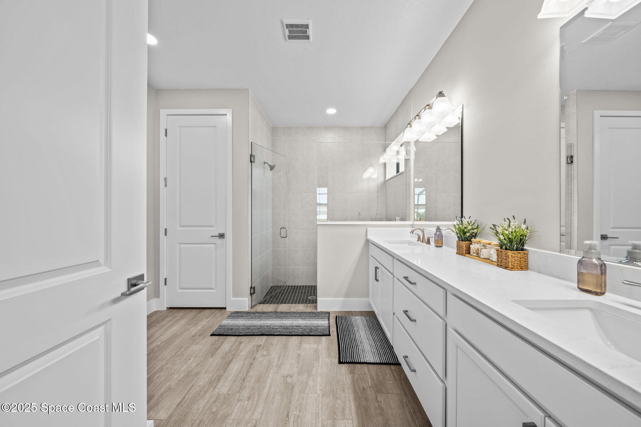 2846 Silverlefe Lane Melbourne, FL 32940 - Photo 22 of 58 a spacious bathroom with a double vanity sink a mirror and a shower