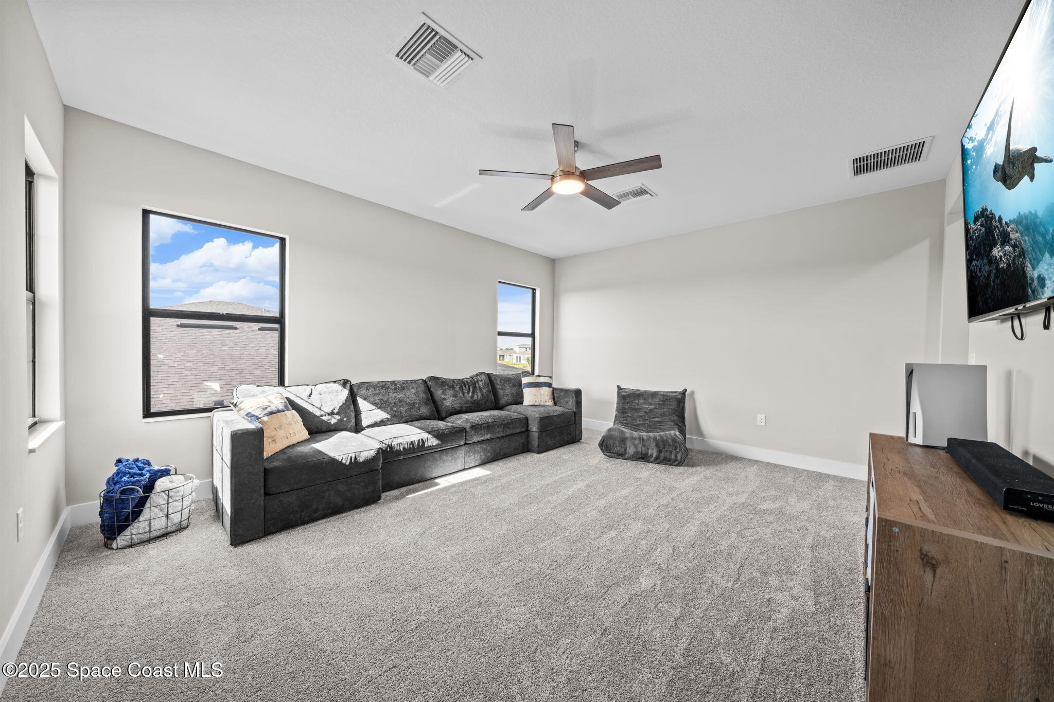 2846 Silverlefe Lane Melbourne, FL 32940 - Photo 39 of 58 a living room with furniture a flat screen tv and a ceiling fan