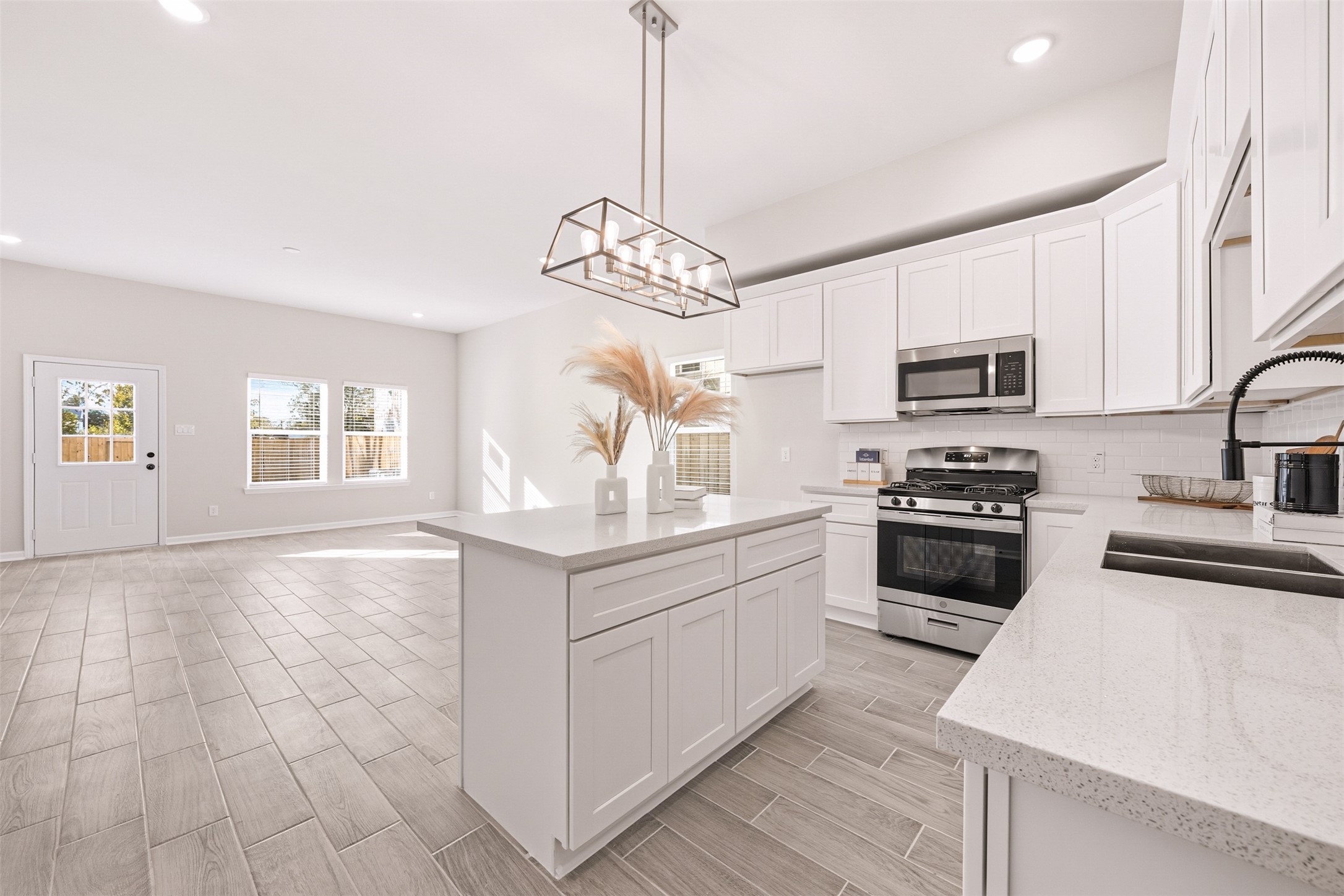 6111 Haight Street Houston, TX 77028 - Photo 5 of 21 a kitchen with stainless steel appliances granite countertop a stove top oven a sink dishwasher a dining table and chairs with wooden floor