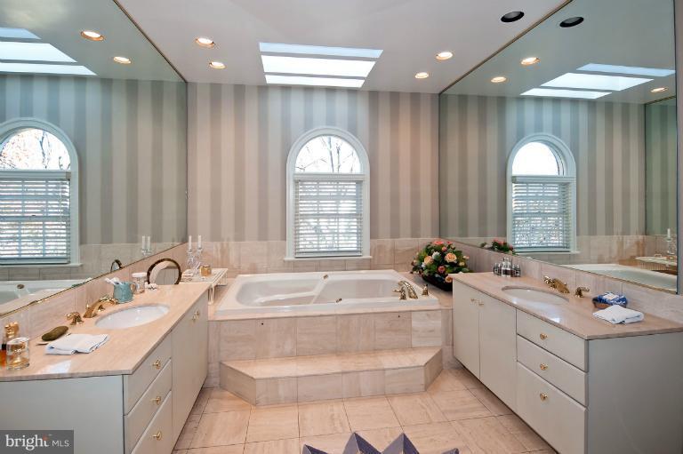 1626 Foxhall Road Northwest Washington, DC 20007 - Photo 12 of 21 a large white bathroom with a double vanity sink a large mirror and a bathtub next to a window