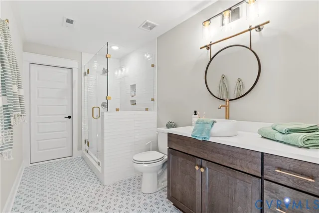 a bathroom with a granite countertop sink toilet a mirror and shower