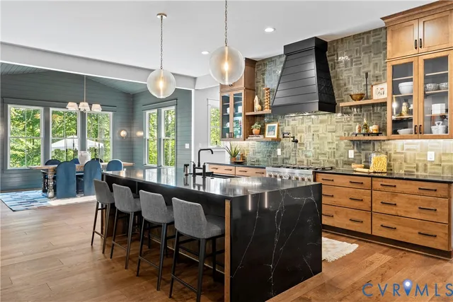 a kitchen with granite countertop wooden cabinets and dining table chairs