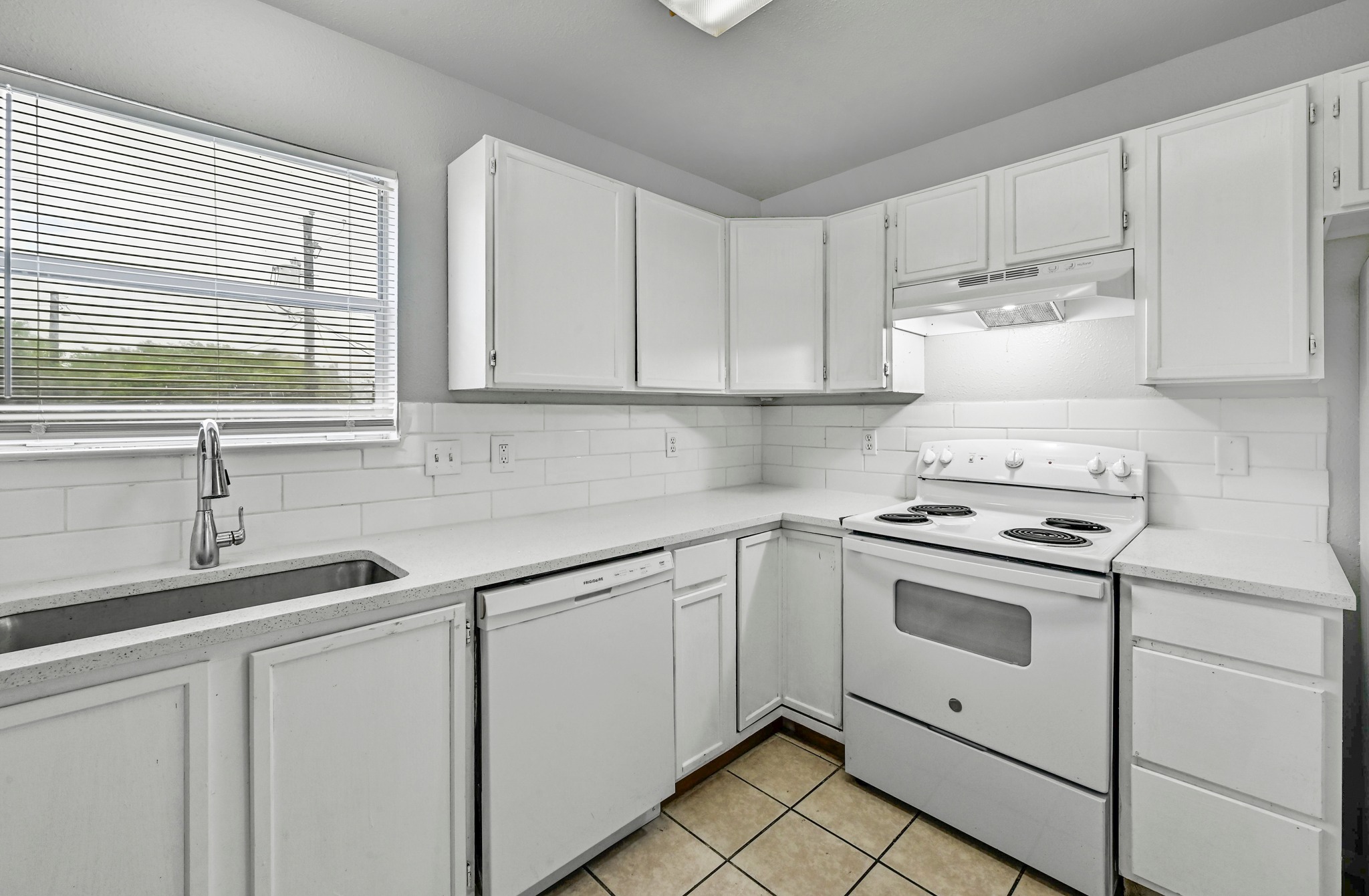 2212 Katy Lane Georgetown, TX 78626 - Photo 13 of 27 The kitchen features white cabinetry, white appliances, light-colored countertops, and a white subway tile backsplash