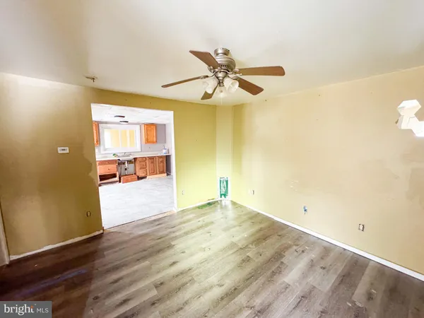 a view of a room with wooden floor and a ceiling fan