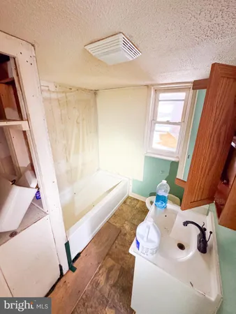 a bathroom with a sink a bathtub and a window
