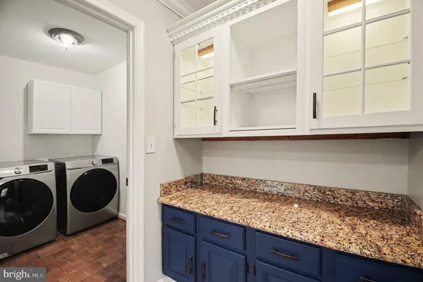 a kitchen with granite countertop cabinets washer and dryer