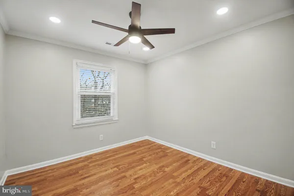 an empty room with a window and ceiling fan