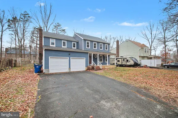 a front view of a house with a yard and a car parked on road