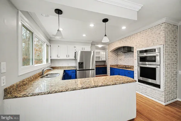 a kitchen with stainless steel appliances granite countertop a sink a oven and a large window
