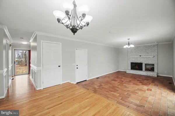 a view of a livingroom with a chandelier wooden floor and a chandelier