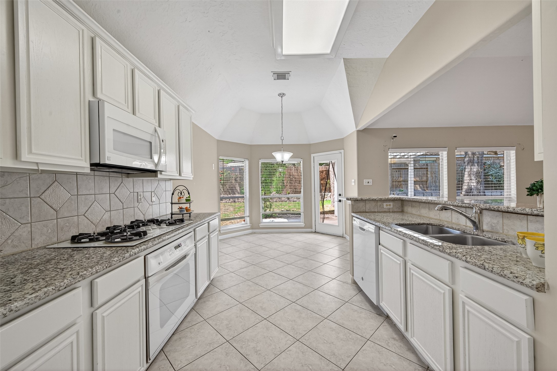 23211 Goldensong Court Spring, TX 77373 - Photo 25 of 46 a kitchen with stainless steel appliances granite countertop a sink stove and cabinets