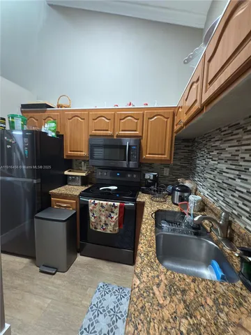 a kitchen with stainless steel appliances granite countertop a sink stove and granite counter top