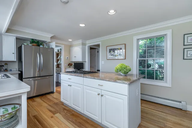 a kitchen with granite countertop a refrigerator and a stove top oven