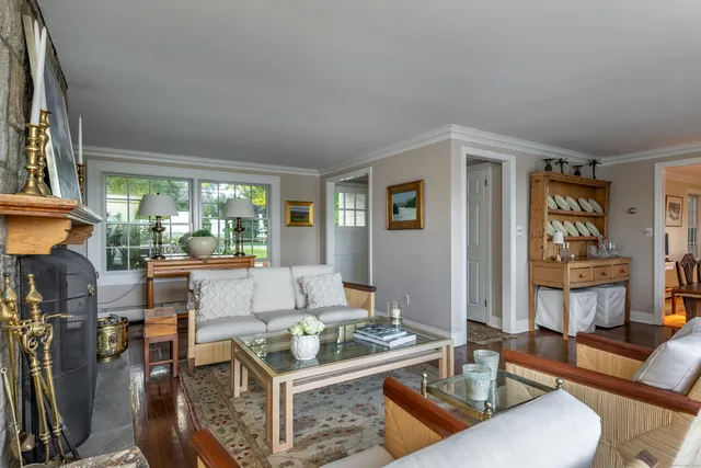 a living room with fireplace furniture and a large window