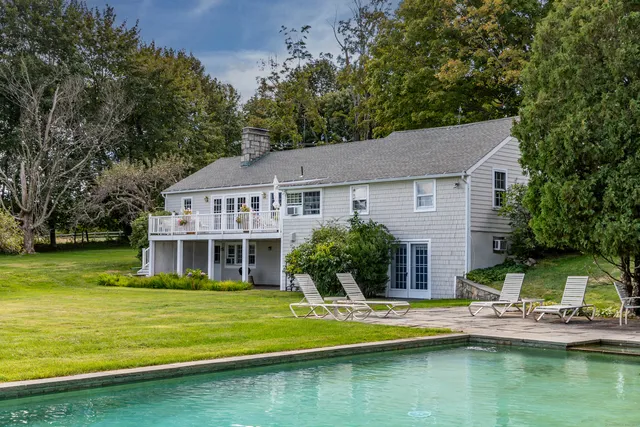 a view of house that has a swimming pool next to a yard
