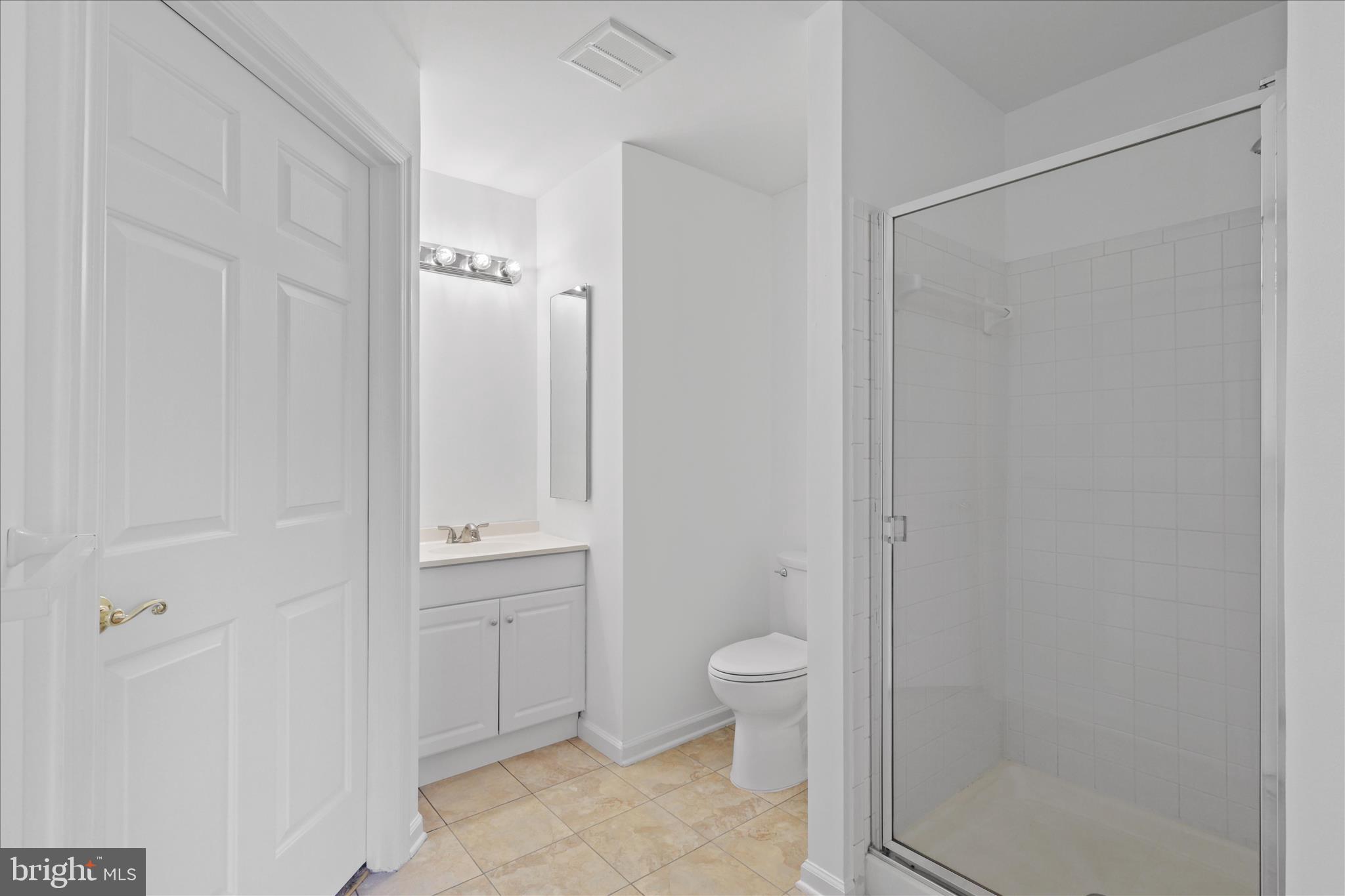 11002 Koman Circle, Unit 103 Manassas, VA 20109 - Photo 17 of 31 a bathroom with a granite countertop sink a toilet and shower
