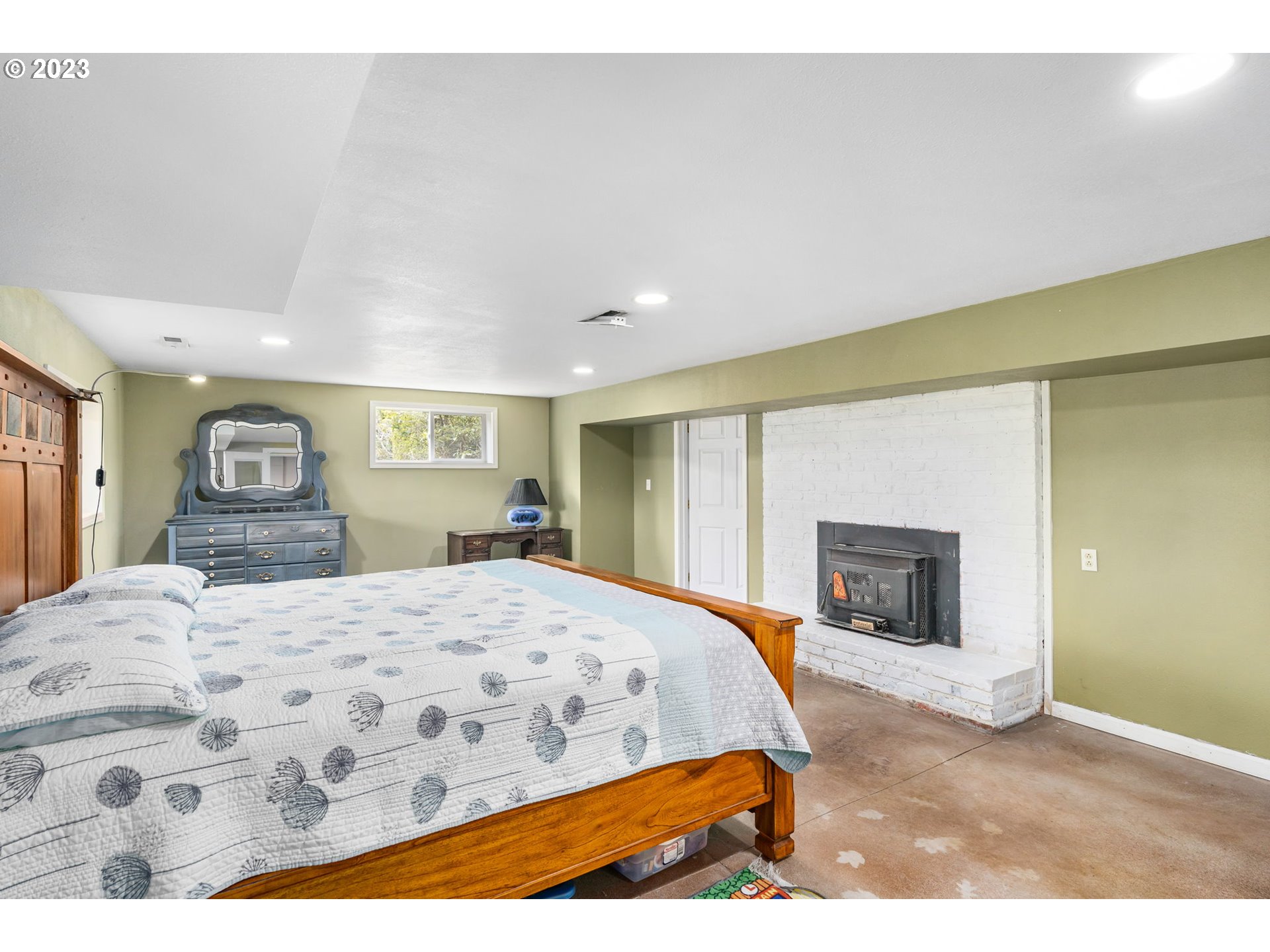 28268 Old Rainier Road Rainier, OR 97048 - Photo 19 of 28 a bedroom with a large bed and a fireplace