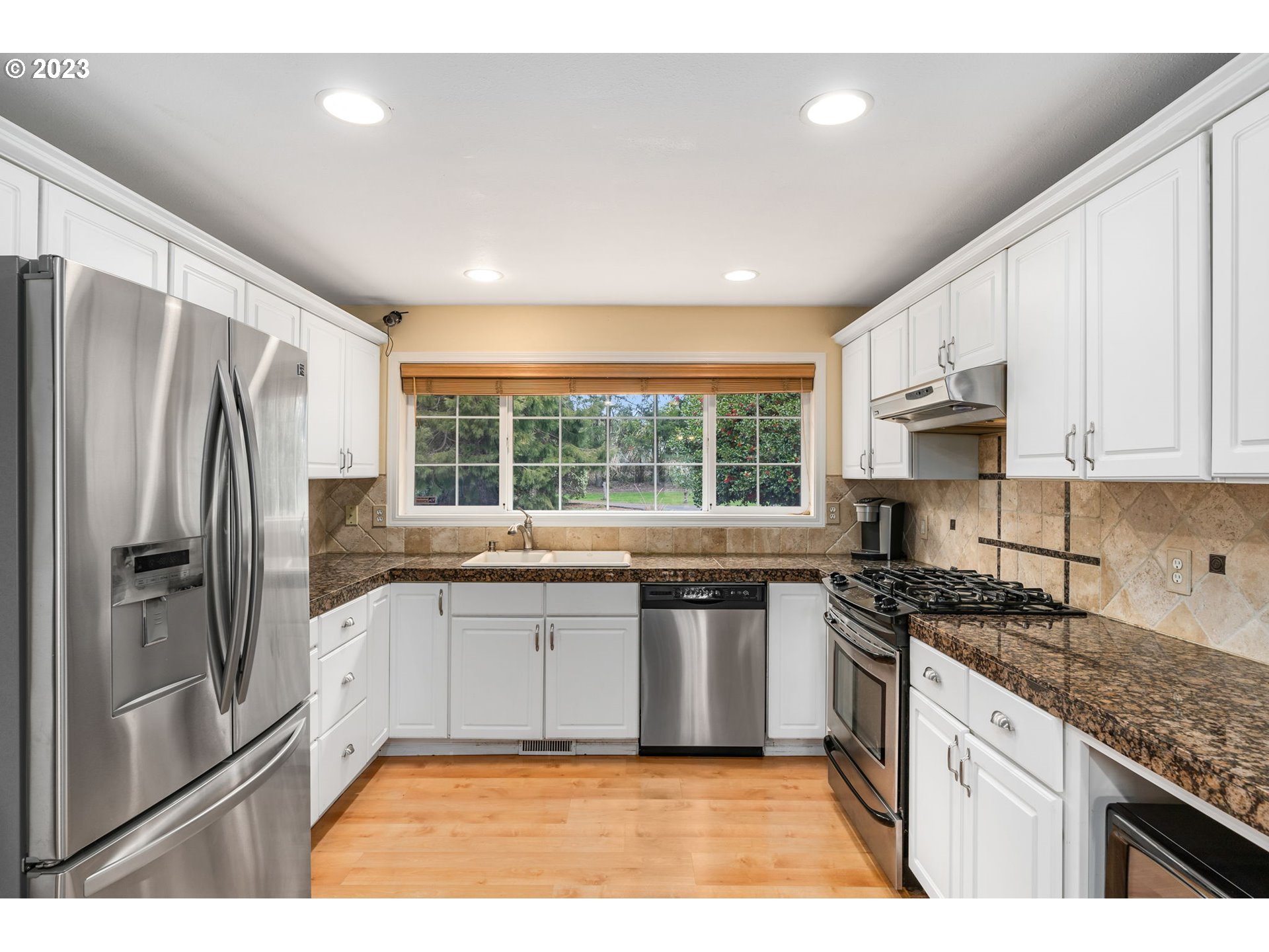 28268 Old Rainier Road Rainier, OR 97048 - Photo 3 of 28 a kitchen with stainless steel appliances granite countertop a stove a sink dishwasher a refrigerator and white cabinets with wooden floor