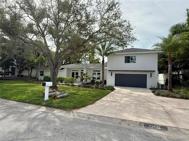 a front view of a house with a yard and trees
