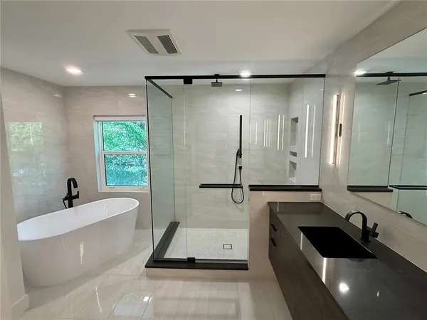 a bathroom with a bathtub sink and mirror