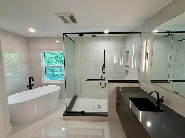 a bathroom with a bathtub sink and mirror