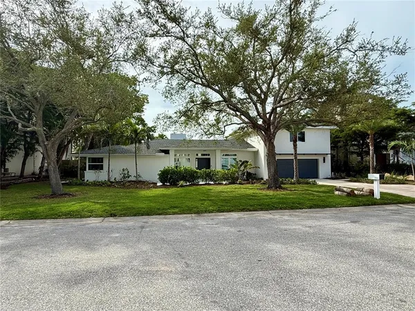 a front view of a house with a yard and trees