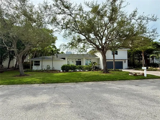a front view of a house with a yard and trees