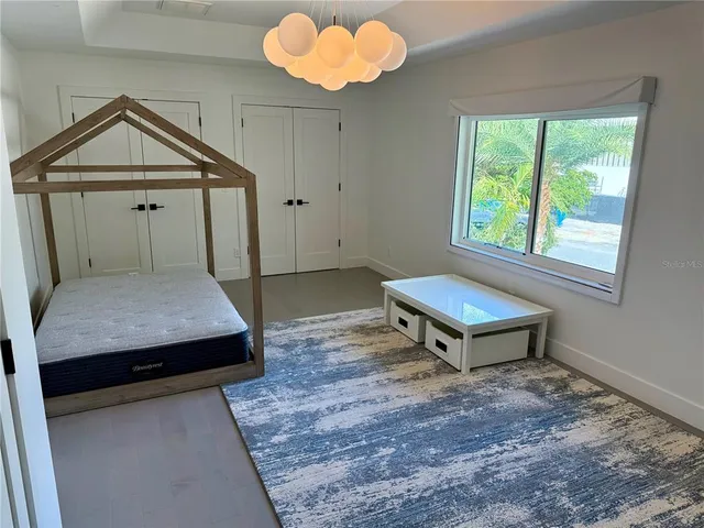 en empty room with windows and chandelier fan