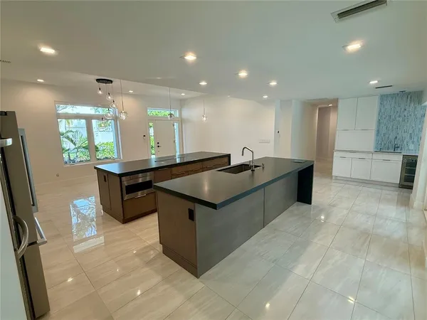 a kitchen with stainless steel appliances granite countertop a sink and a refrigerator