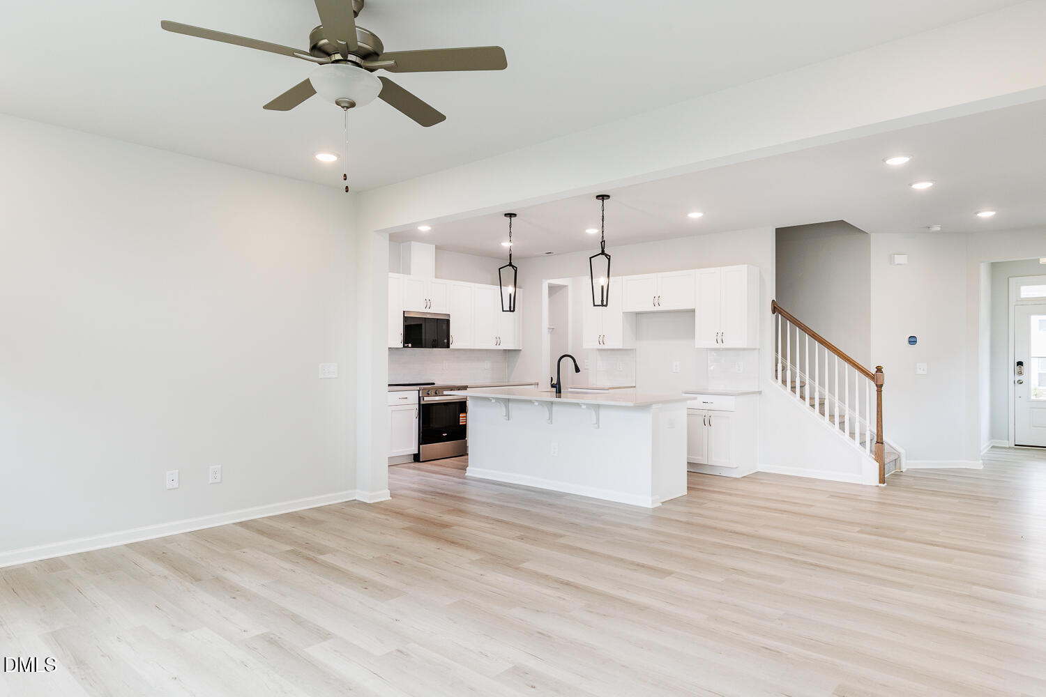 144 Siebold Street Garner, NC 27529 - Photo 20 of 40 a large white kitchen with kitchen island a sink wooden floor and stainless steel appliances