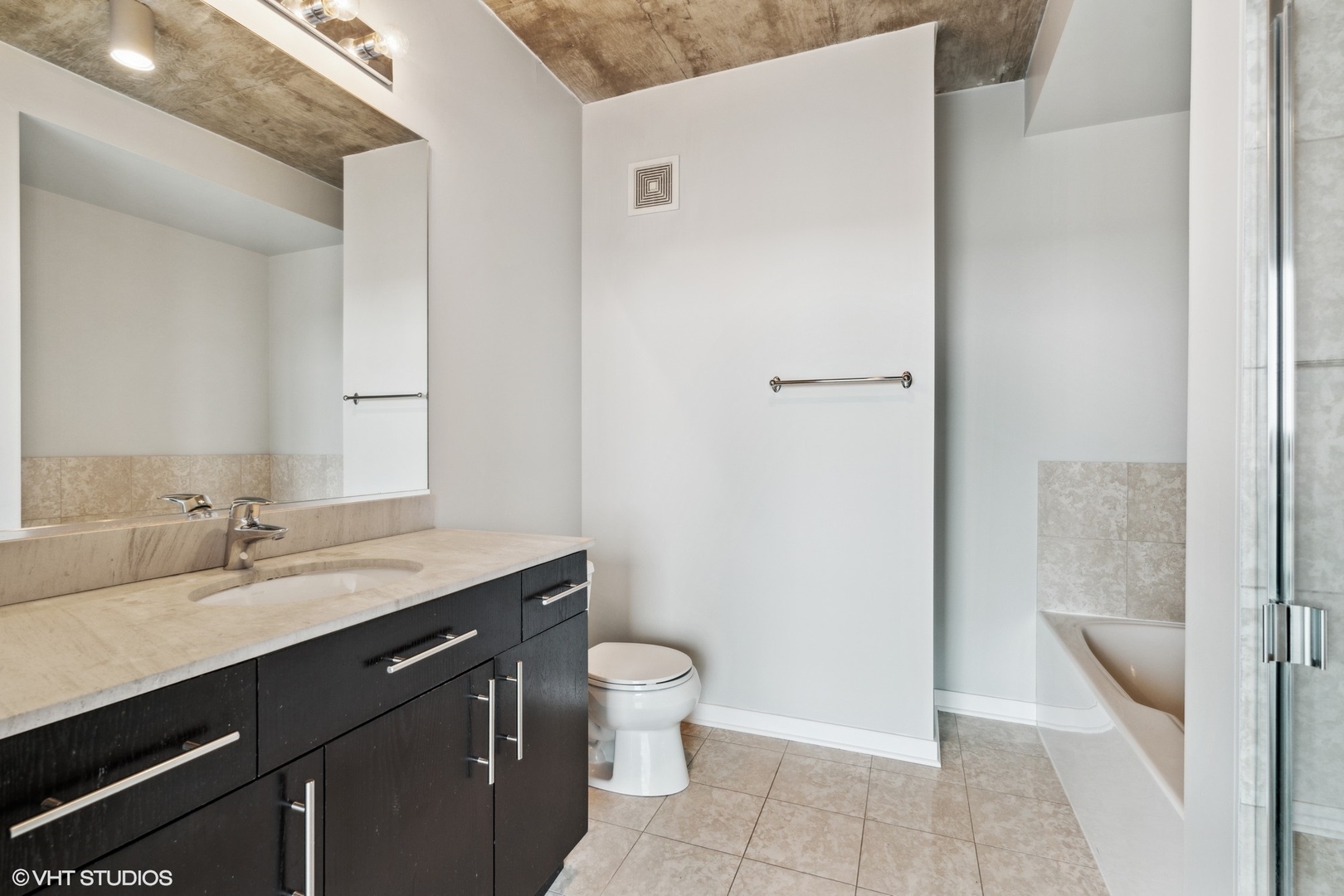 611 South Wells Street, Unit 2705 Chicago, IL 60607 - Photo 15 of 23 a bathroom with a granite countertop sink a toilet and a shower