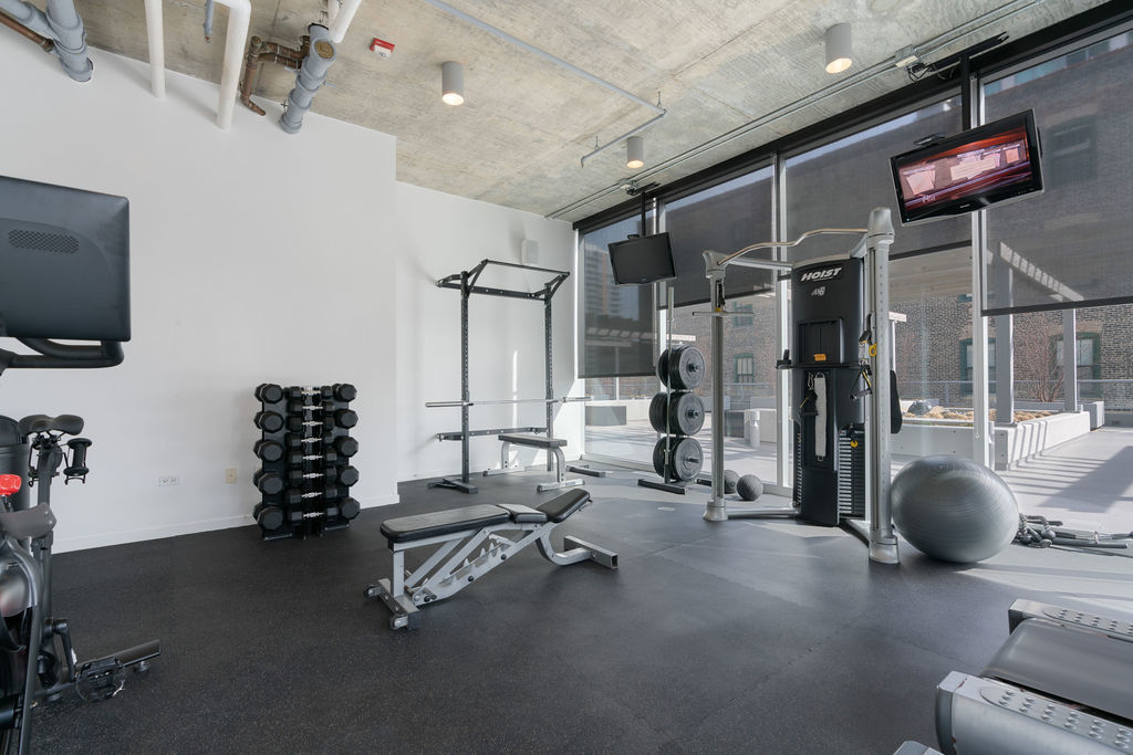 611 South Wells Street, Unit 2705 Chicago, IL 60607 - Photo 22 of 23 a room with gym equipment and a flat screen tv