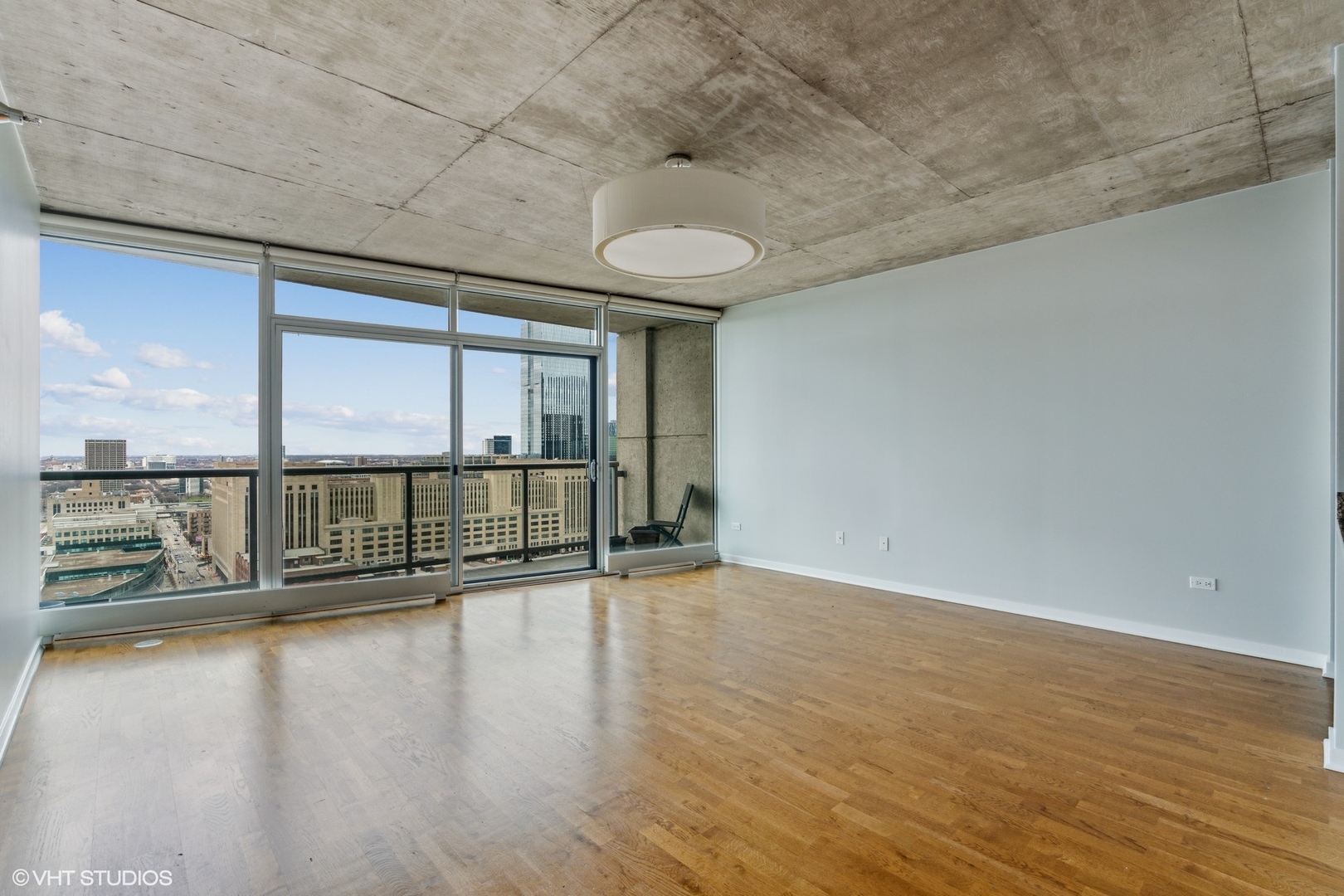 611 South Wells Street, Unit 2705 Chicago, IL 60607 - Photo 3 of 23 a view of an empty room with wooden floor and a window