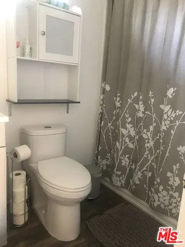 a bathroom with a toilet and a shower curtain