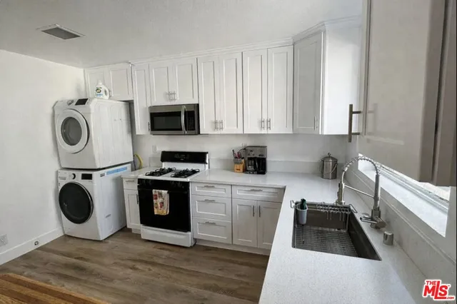 a kitchen with a refrigerator and a stove top oven