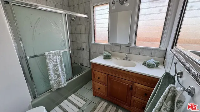 a bathroom with a sink a mirror and shower