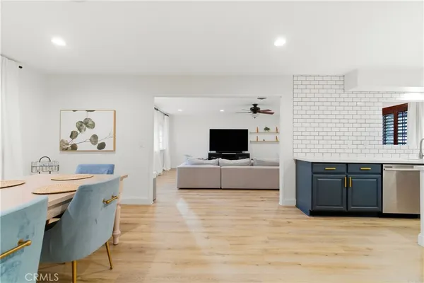 a living room with furniture a flat screen tv and kitchen view