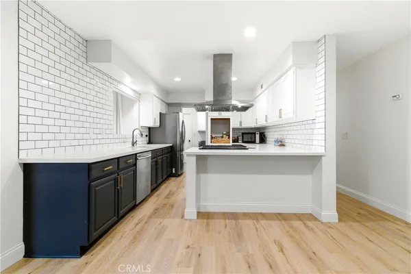 a kitchen with stainless steel appliances granite countertop a sink and wooden cabinets
