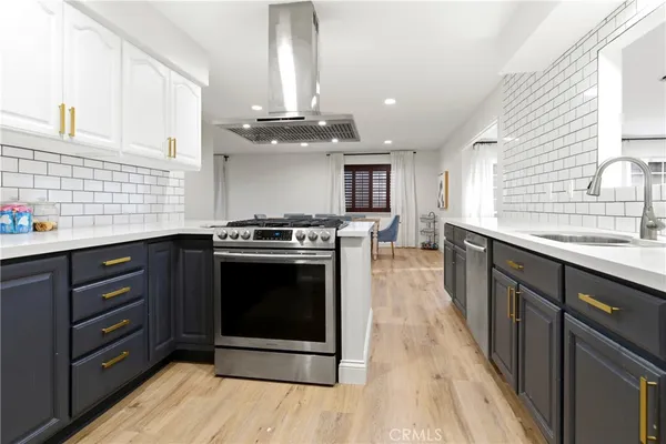a kitchen with stainless steel appliances granite countertop a stove a sink and a microwave