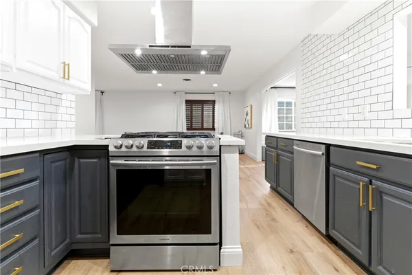 a kitchen with stainless steel appliances granite countertop a stove a sink and a microwave
