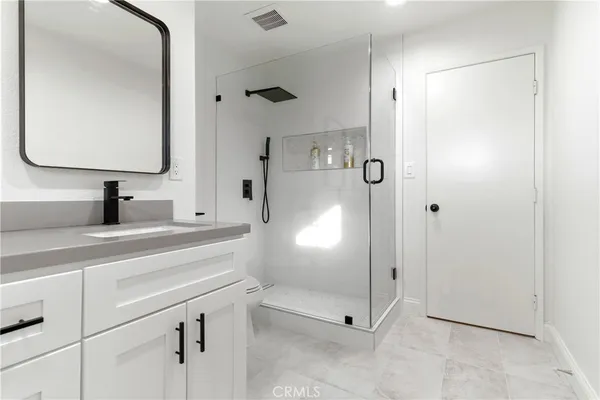 a bathroom with a shower sink and mirror