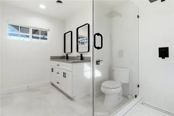 a bathroom with a granite countertop sink toilet and shower