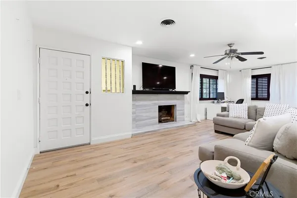 a living room with furniture a fireplace and a flat screen tv