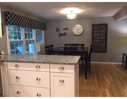 2 Virginia Road Tyngsborough, MA 01879 - Photo 3 of 11 a kitchen with granite countertop a table chairs and white cabinets
