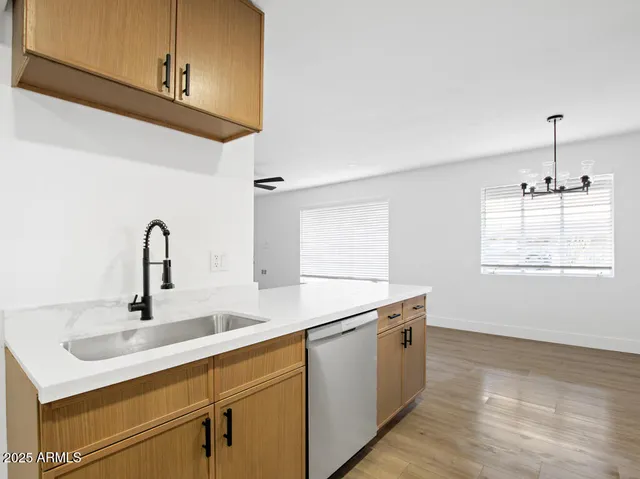 a kitchen with stainless steel appliances a sink dishwasher a microwave oven and a stove with granite countertops