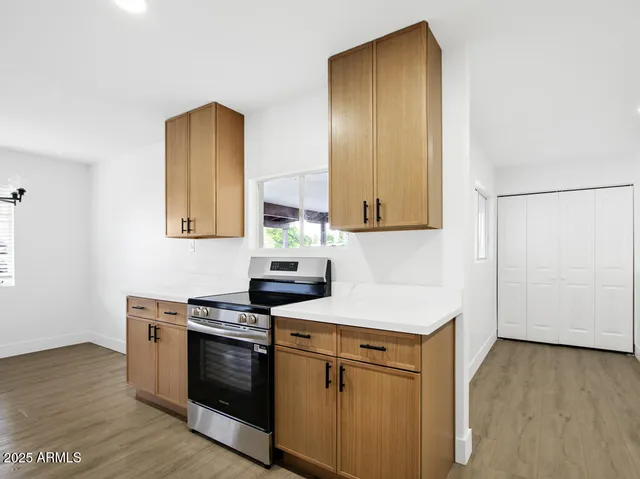 an empty room with wooden floor and cabinet