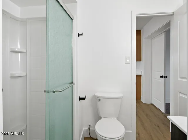 an empty room with windows fireplace and a ceiling fan