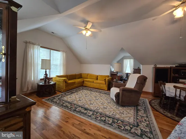 a living room with furniture ceiling fan and a rug